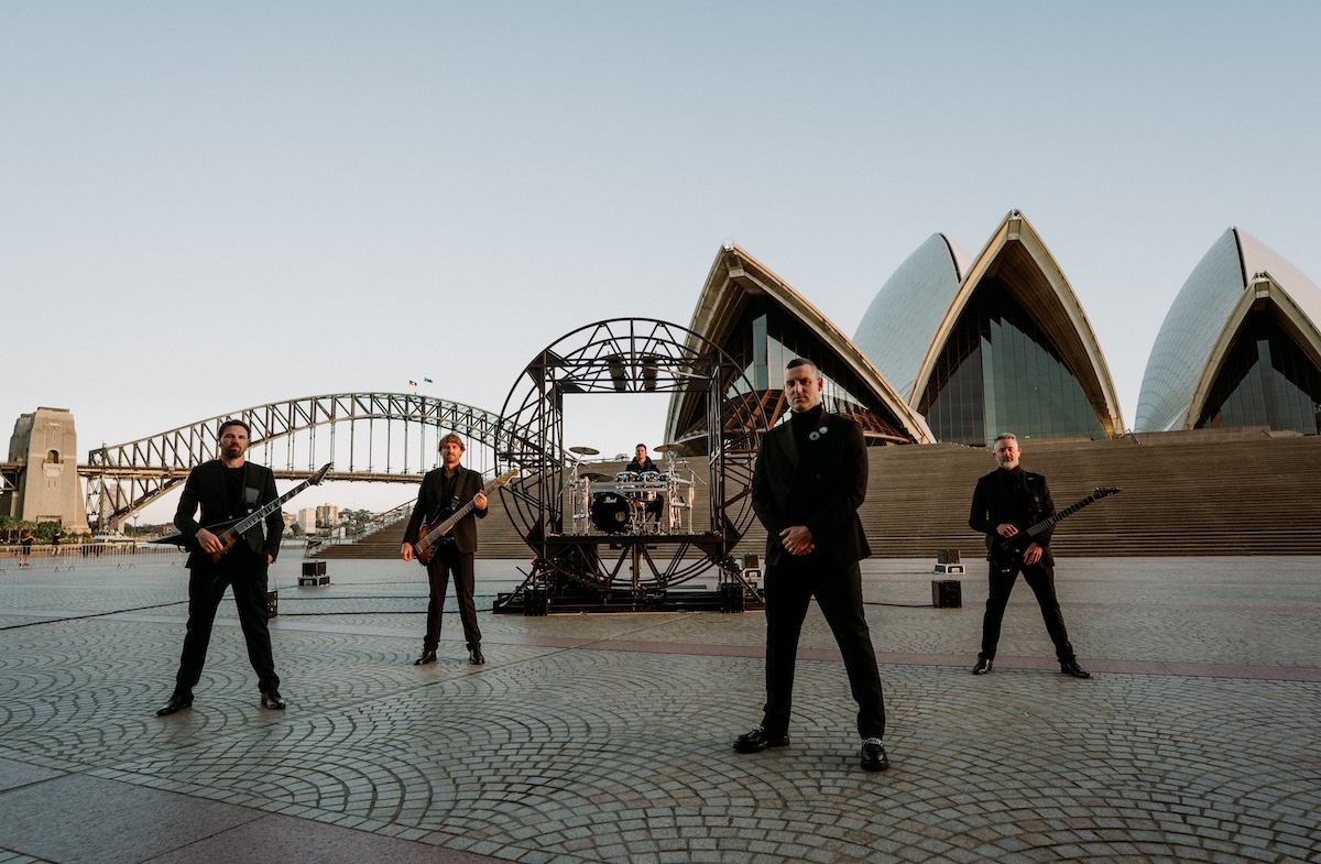 Australian metalcore band Parkway Drive posing in black suits in front of the Sydney Opera House and Harbour Bridge